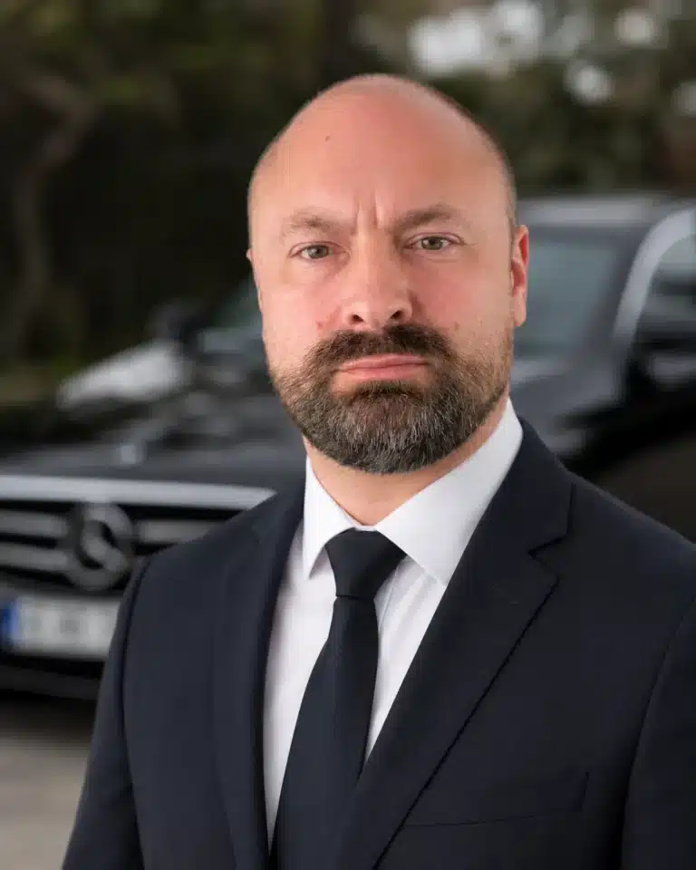 Adrien, fondateur d'AP Prestige Driver, chauffeur privé dans le Var (83) VTC haut de gamme, en costume devant sa Mercedes