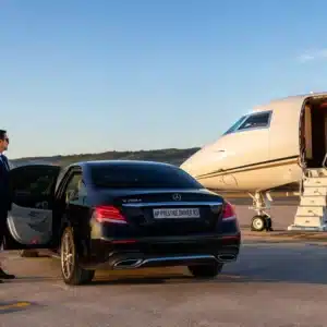 Mercedes Classe E noire AP Prestige Driver sur le tarmac à côté d'un jet privé, transfert aéroport avec chauffeur VTC Var